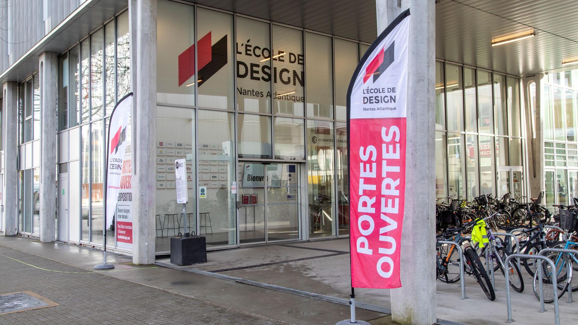 Photo de l'extérieur de l'école où l'on voit l'on l'entrée de l'école avec une flamme où s'est écrit : portes ouvertes